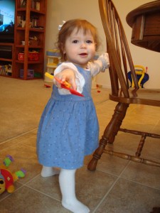 bluedress 002 Peytra standing and holding her play kitchen utensils
